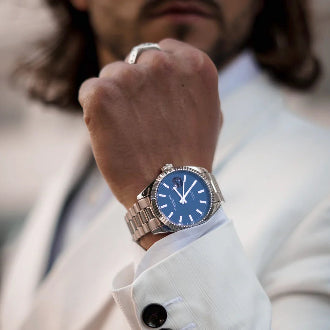 Person wearing a blue watch with a blurred background